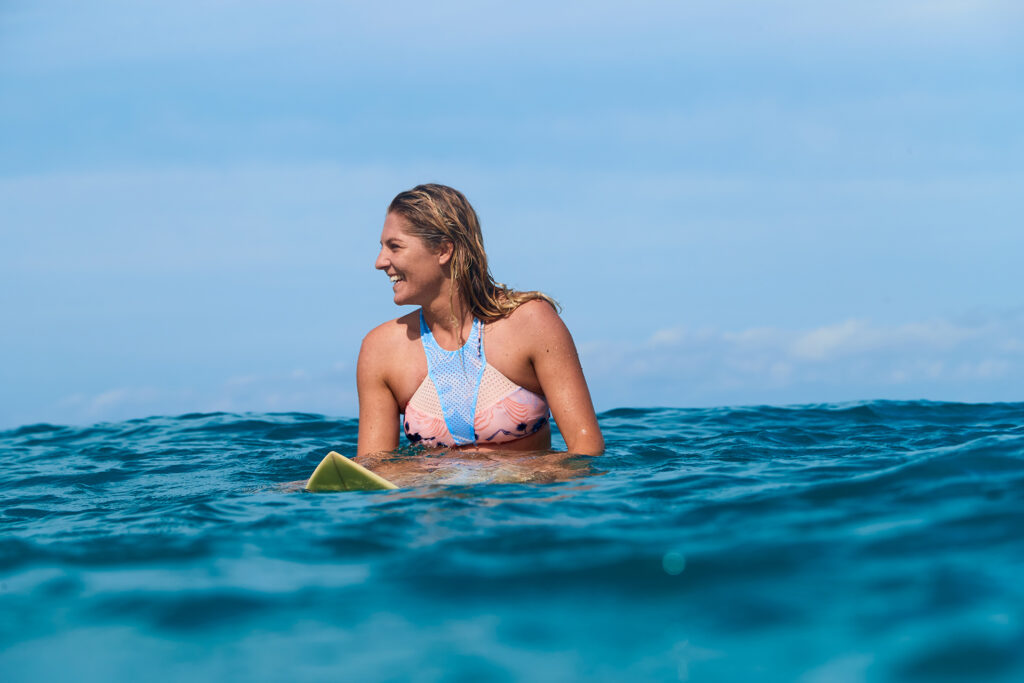 Stephanie Gilmore souriante sur sa planche de surf